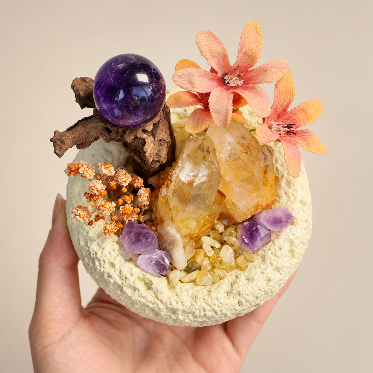 Angled handheld view of citrine chips, amethyst sphere and wood accents