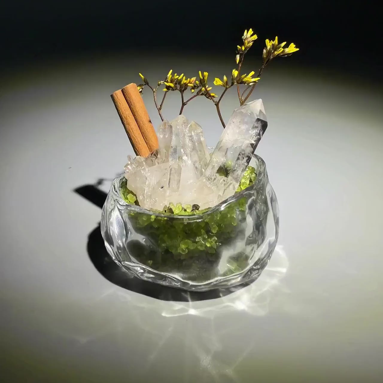 Finished clear quartz and peridot crystal garden in sunlight.