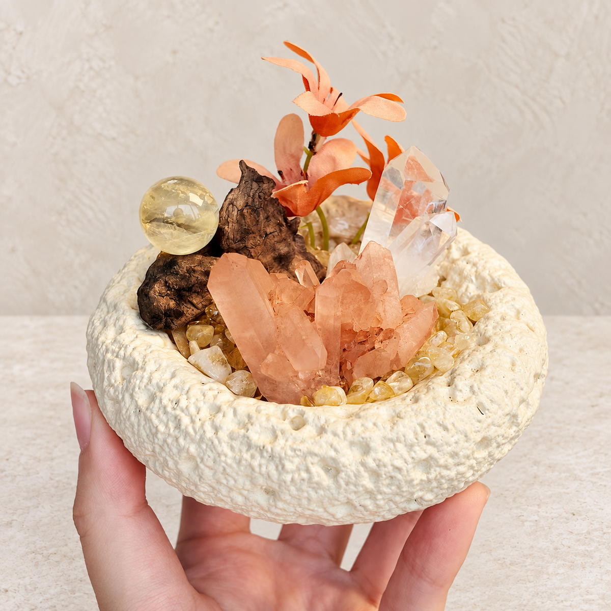 Handheld red quartz and citrine crystal garden showing the compact textured bowl